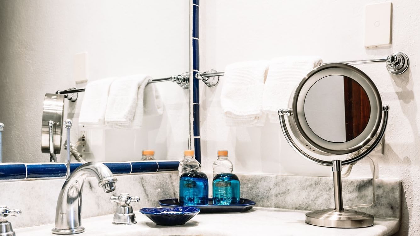 Bathroom counter with a large mirror and amenities in the King Governor Suite at Quinta Real Oaxaca