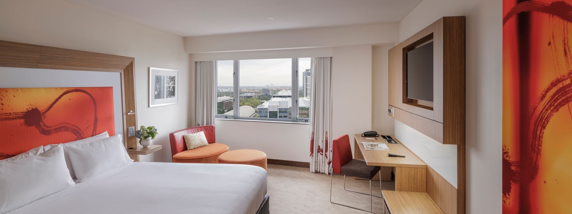 Wall-mounted TV, work desk & cozy seating area by the bed in Superior Room at Novotel Sydney Olympic Park