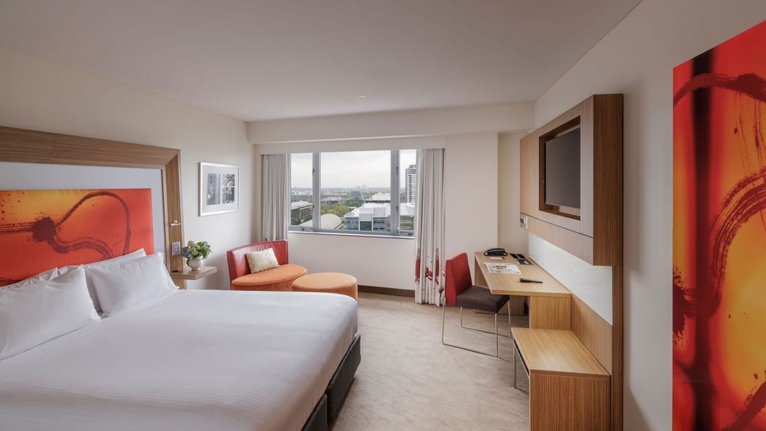 Wall-mounted TV, work desk & cozy seating area by the bed in Superior Room at Novotel Sydney Olympic Park