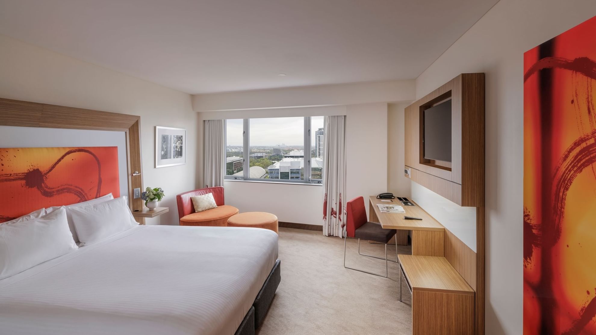 Wall-mounted TV, work desk & cozy seating area by the bed in Superior Room at Novotel Sydney Olympic Park