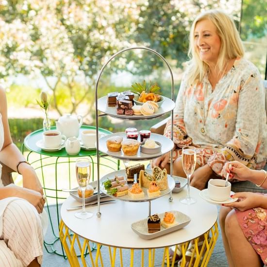 Ladies enjoying Mother's day high tea platter at Pullman Magenta Shores