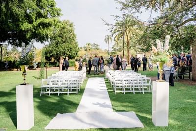 A beautiful outdoor wedding ceremony is set up on the lawn at the Royal on the Park Hotel