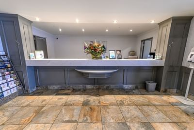 Front desk with flower arrangement in lobby area at Service Plus Inns & Suites
