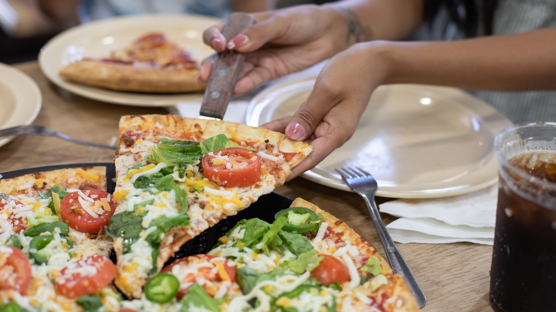 Close-up of girl holding Pizza slice from Bruno’s Pizza at Watersound Inn