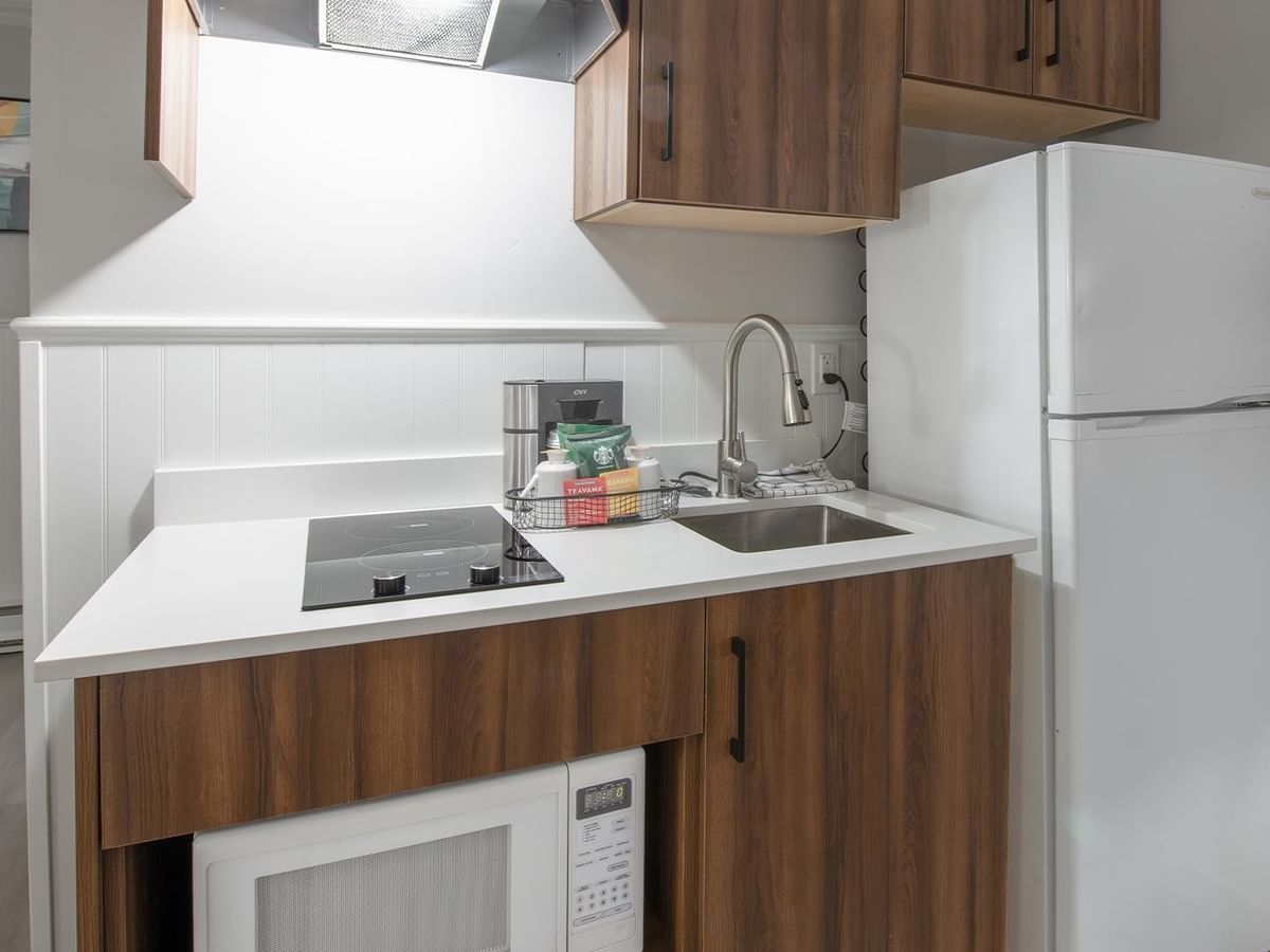 Kitchenette with microwave, sink, and fridge.