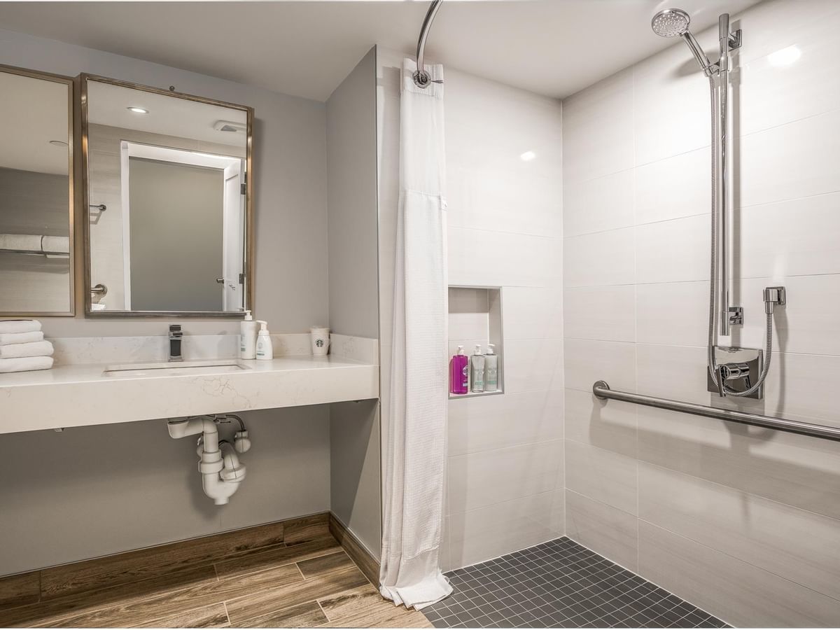 View of our roll-in shower with grab bars and adjustable shower-head in our accessible bathroom
