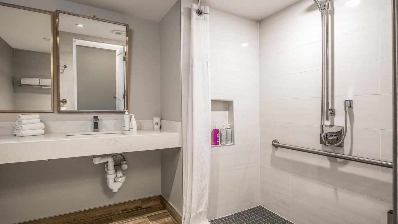 View of our roll-in shower with grab bars and adjustable shower-head in our accessible bathroom