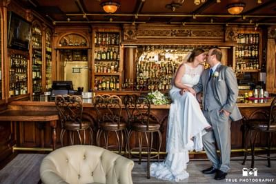 Bride and groom kissing by the bar at Horton Grand Hotel