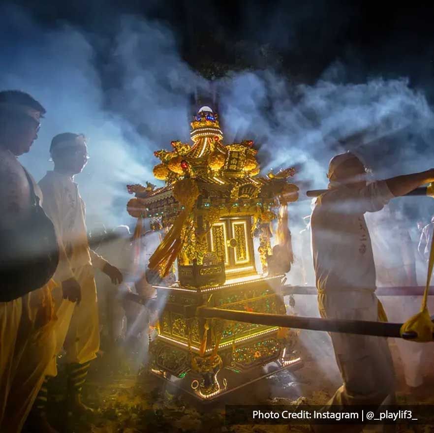 A ritual is carried out with statues on sedan chairs and a sacred urn alongside with lion dance.