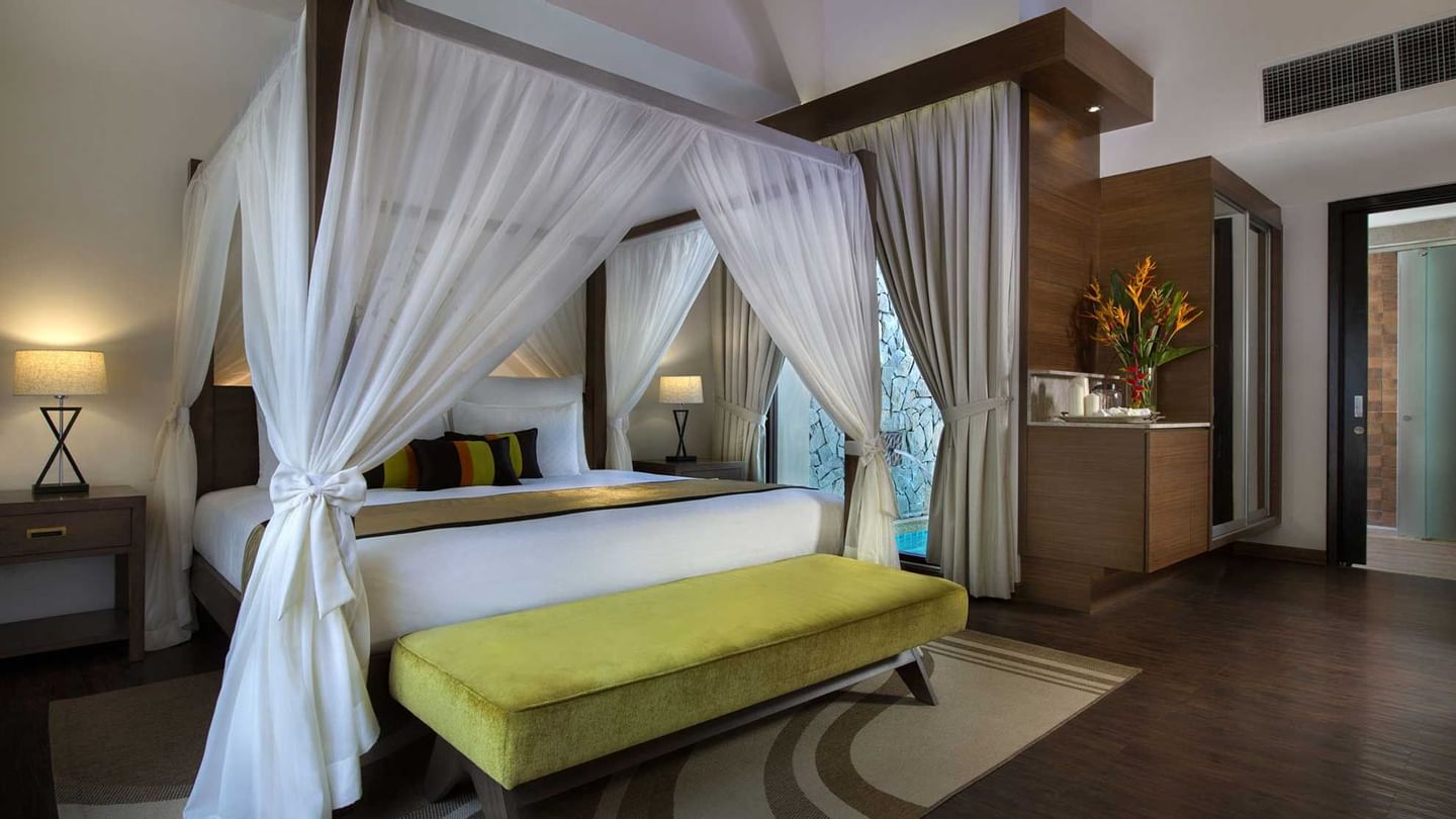 Spacious Lake Villa bedroom, lime green bench, and dark wood floors at The Banjaran Hotsprings Retreat