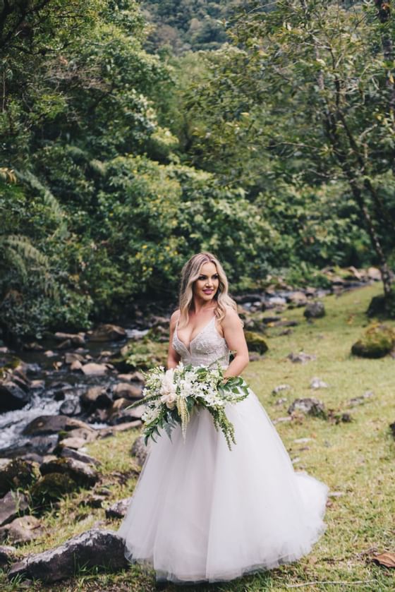 una mujer con un vestido de novia sosteniendo flores
