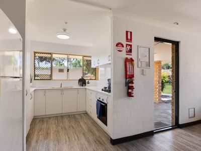 Modern kitchen with white cabinets, appliances, and wooden floor at UniLodge Vickery House.