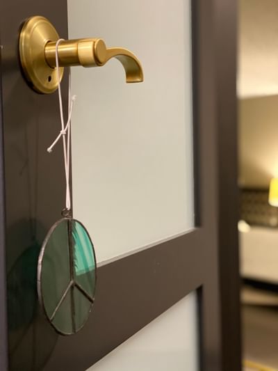 a glass peace sign hanging from a door handle