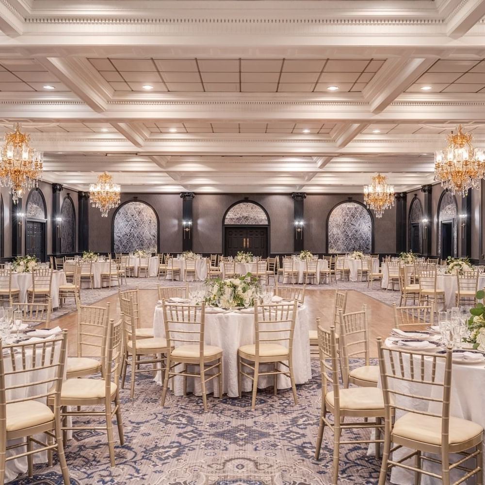 Elegant ballroom with round tables and chairs set up for an event.