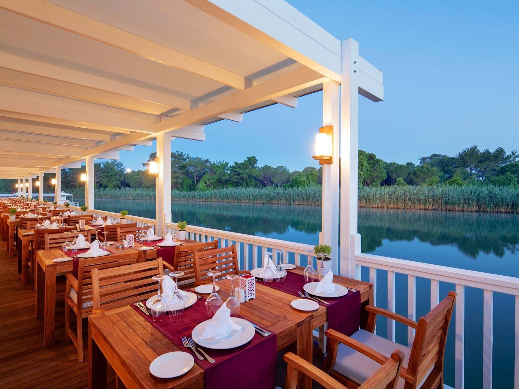 Dining setup on wooden deck in Hasır Turkish Restaurant at Titanic Deluxe Golf Belek