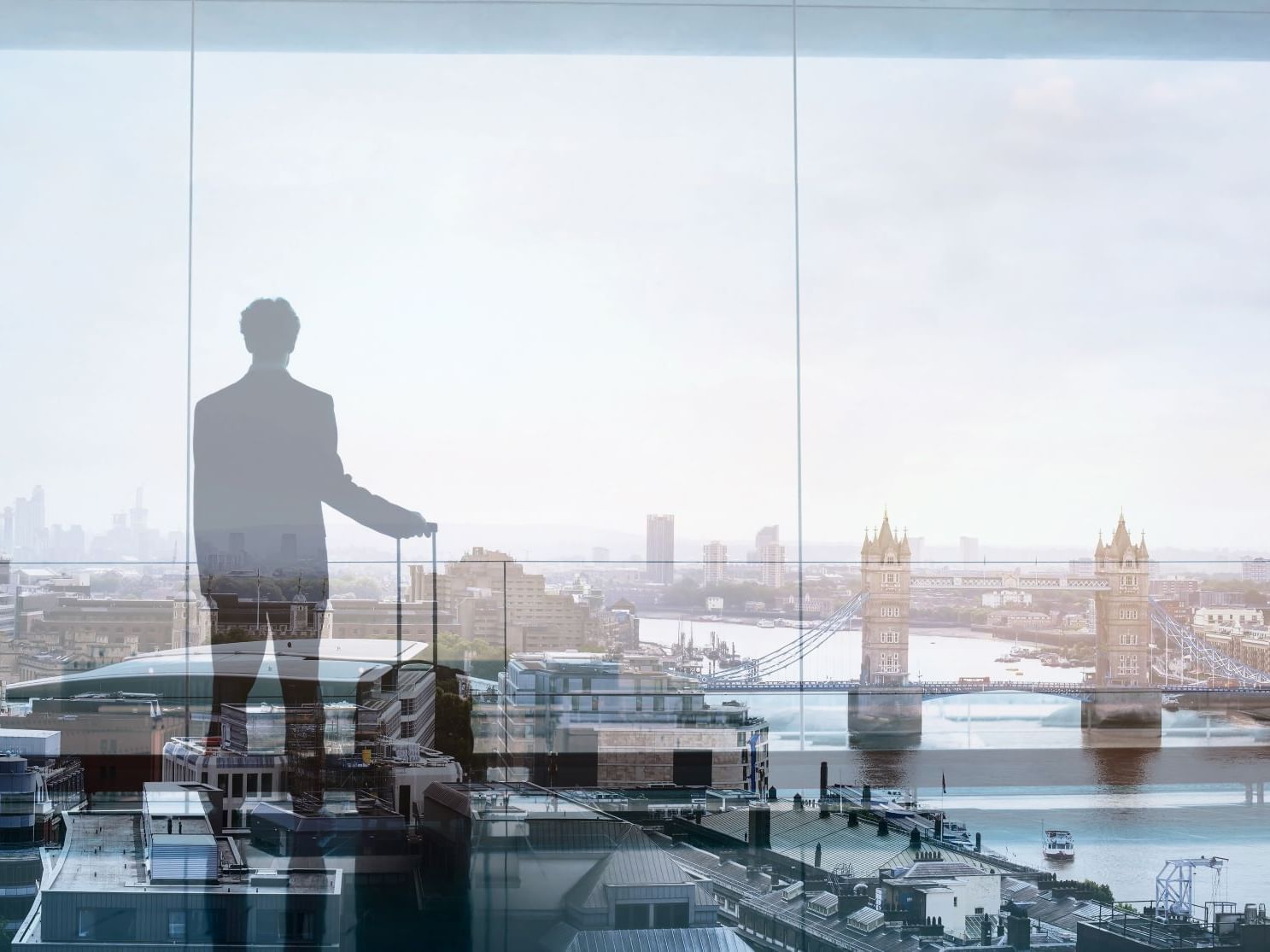 silhouette of male business traveller looking at london skyline