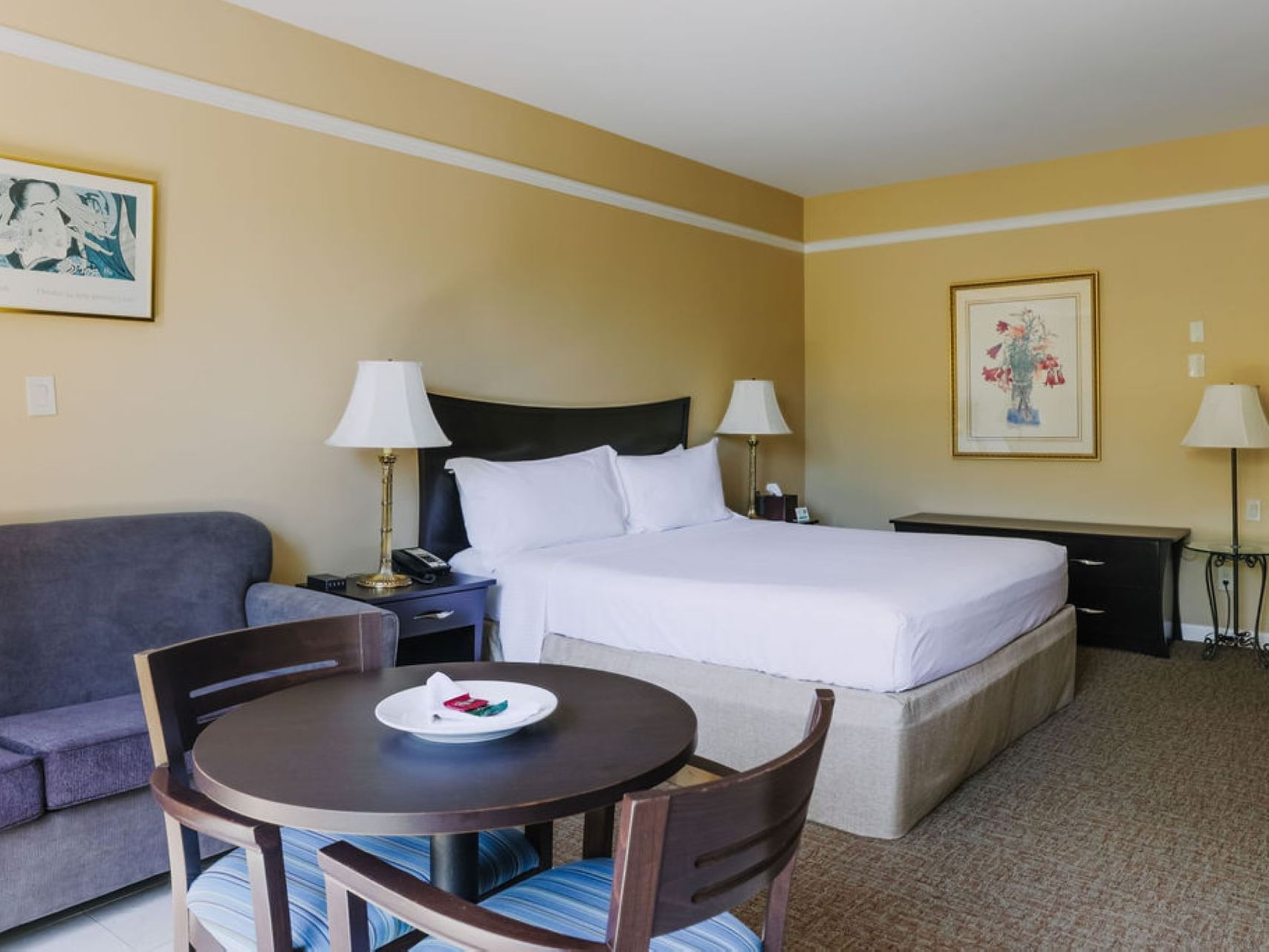 Large bed & table in Lagoon Room at Dinah's Garden Hotel