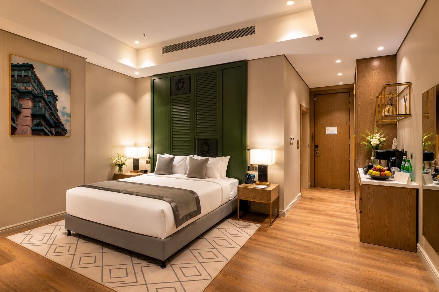 Executive Suite featuring king bed and a minibar counter beside a wooden hallway door at Naviti by Warwick Jeddah