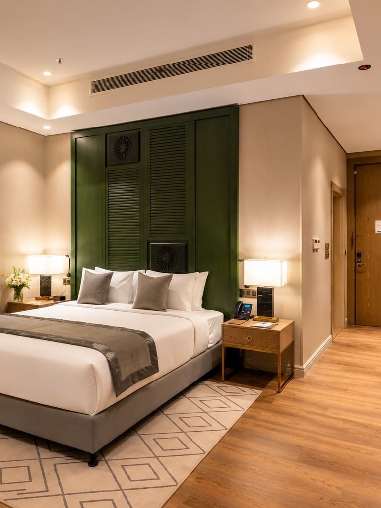 King bed and a minibar counter beside a hallway door at Naviti by Warwick Jeddah, offering a comfortable boutique stay