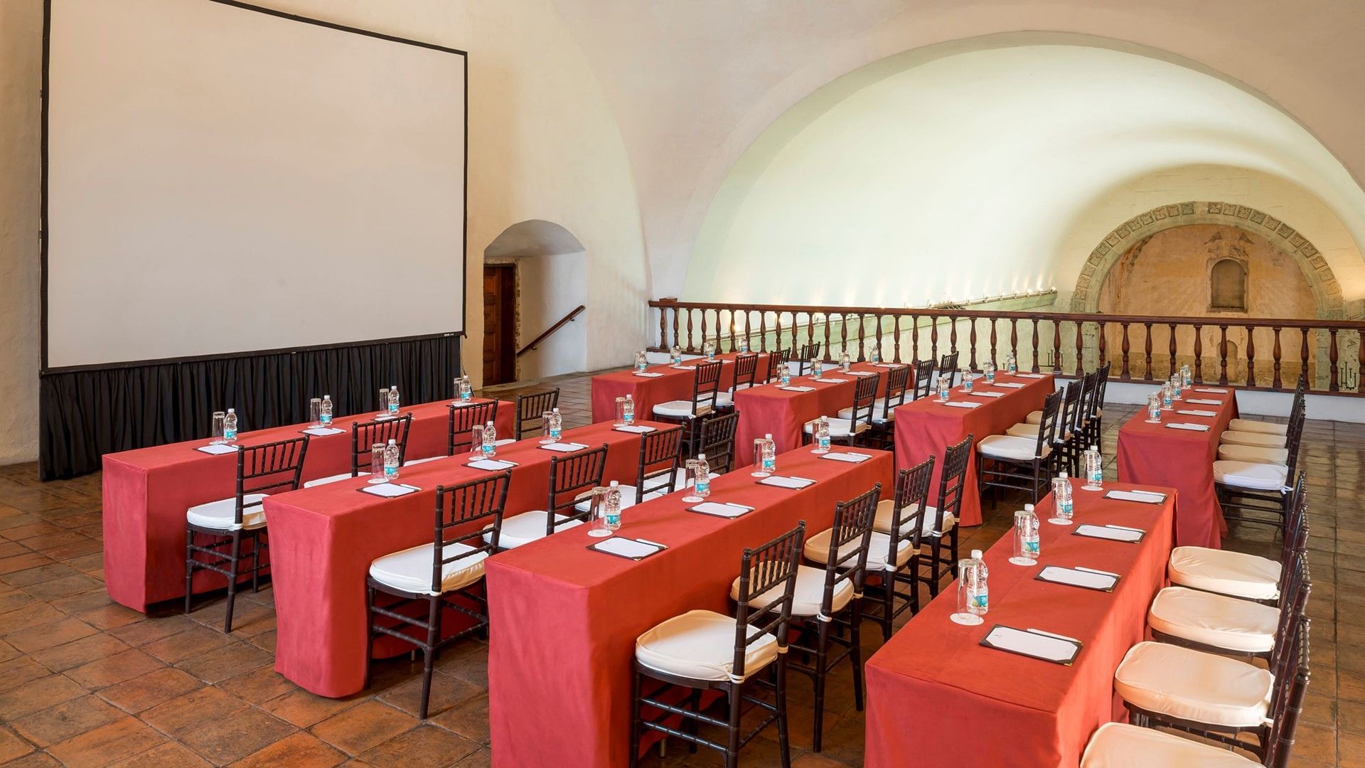 Classroom set-up with water bottles and a projector screen in Novicias Salon at Quinta Real Oaxaca