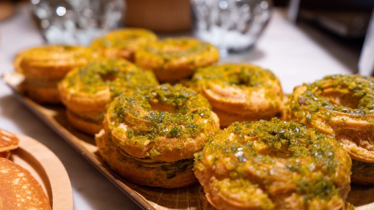 Toasted baguettes topped with green pesto on a wooden serving board at Warwick Paris Champs Elysées