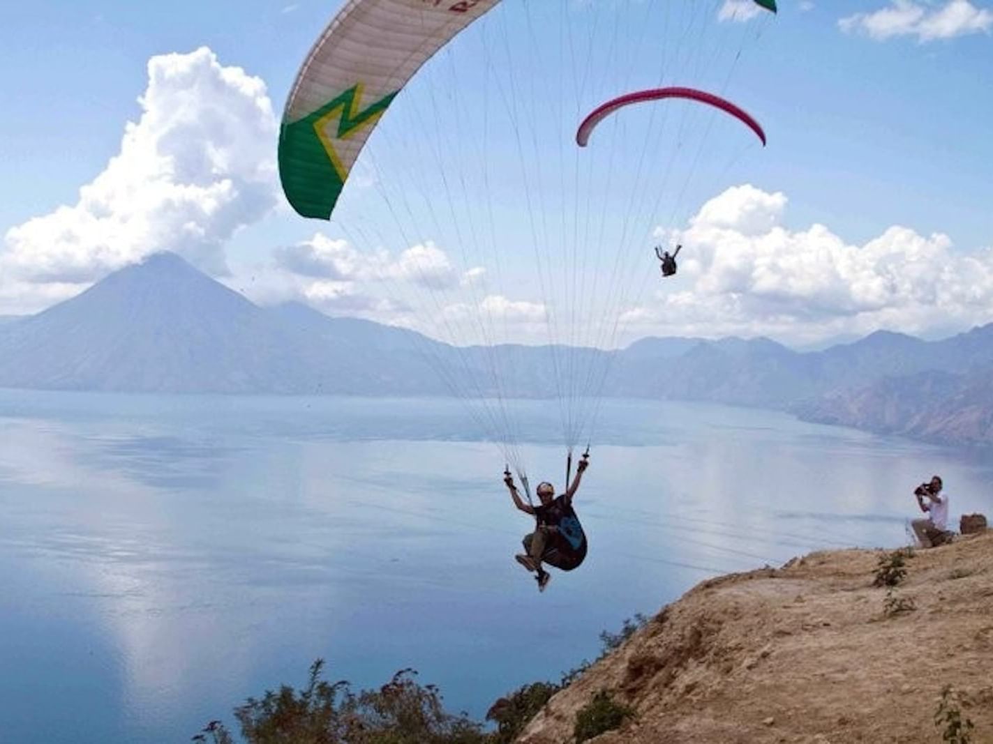 Two people paragliding over Lake Atitlán near Porta Hotel del Lago