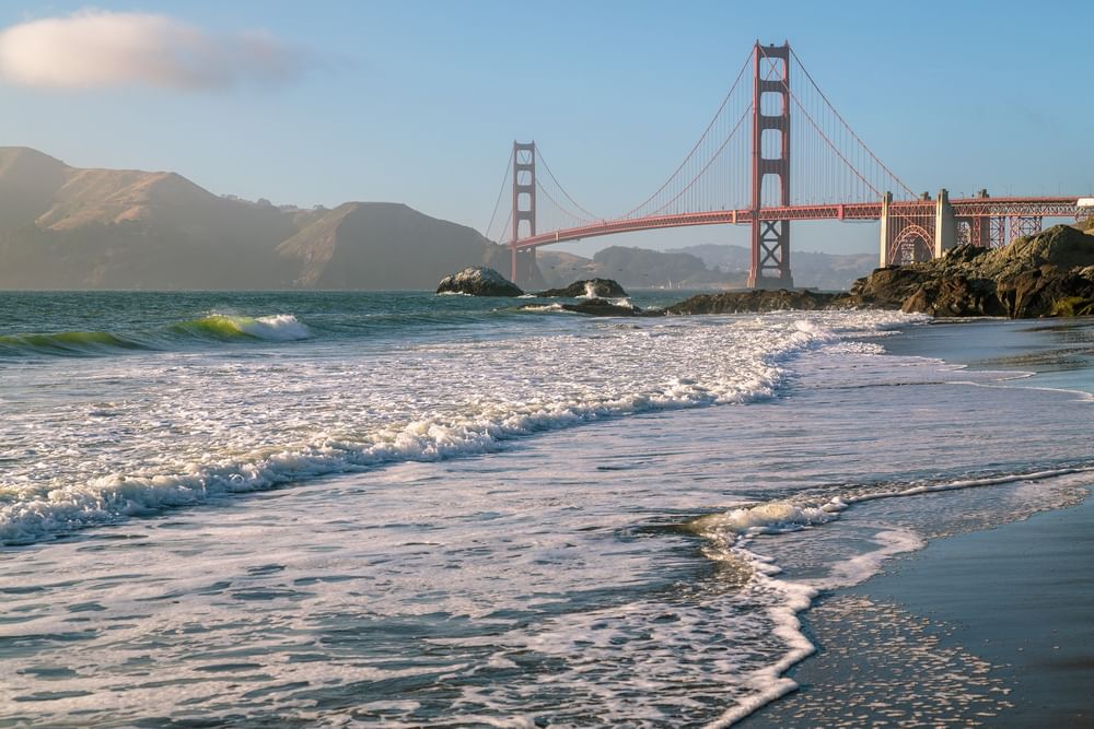 Ocean waves by a sandy beach under the Golden Gate Bridge near Warwick San Francisco