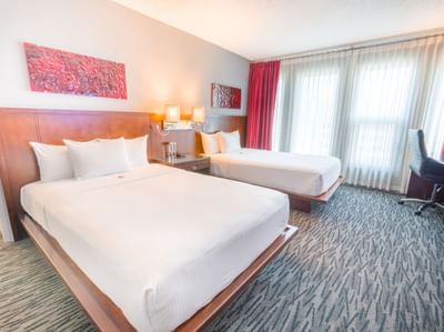Two beds with nightstand and workspace in Deluxe Two Double at Matrix Hotel