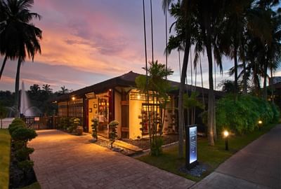 Elegant Ti Chen restaurant entrance at dusk, with warm lights and palm trees at The Saujana Hotel Kuala Lumpur