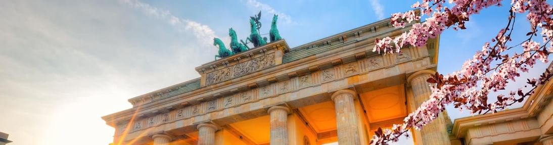 Sunset at Brandenburg Gate with people near Titanic Comfort Mitte