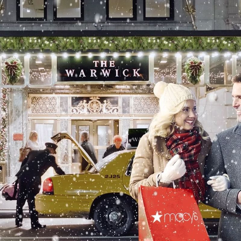 Couple in front of the Warwick New York with a Macy's bag