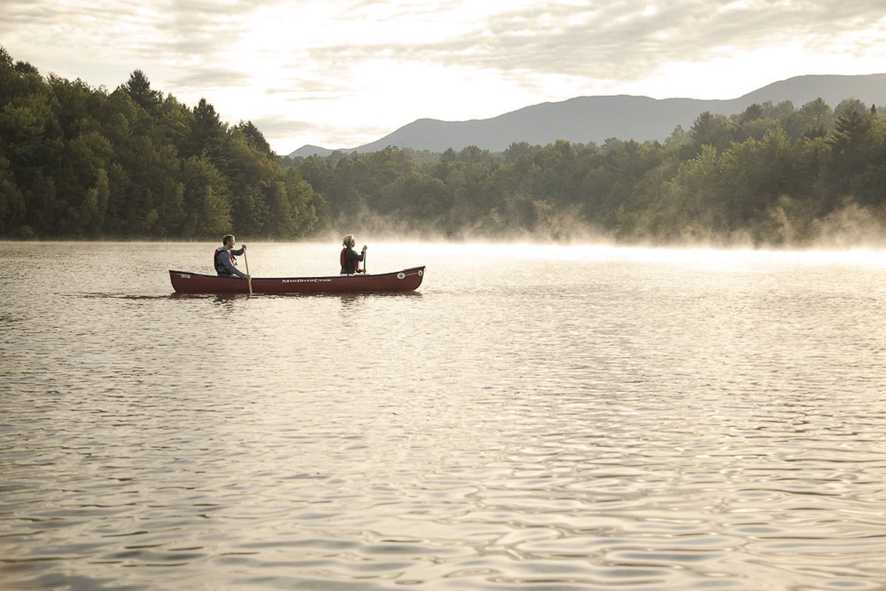 Two friends canoeing in a misty Vermont morning.