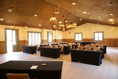 Classroom set up featuring bottles on tables by chairs under wood ceiling in Carmenere Meeting Room at NOI Blend Colchagua