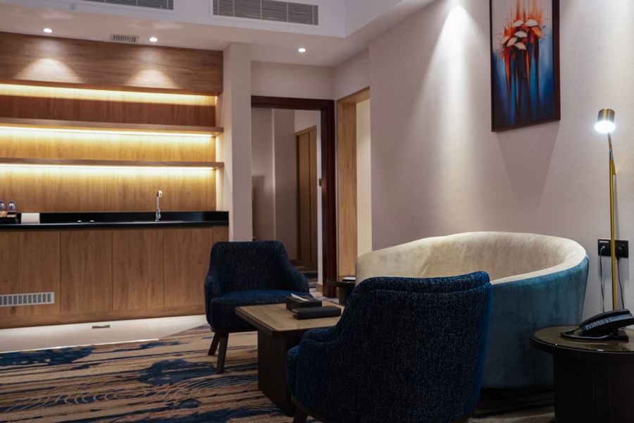Modern lounge with blue chairs and artwork at Warwick Hotel & Spa - Jeddah.