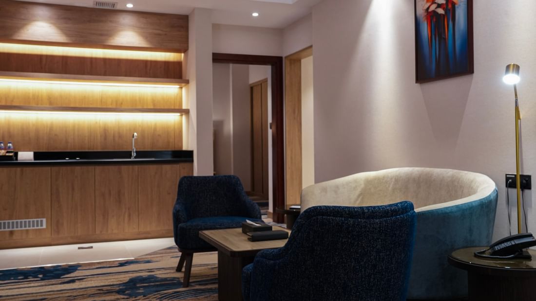 Cozy seating area with modern decor and artwork in the One Bedroom Suite at Warwick Hotel & Spa - Jeddah.