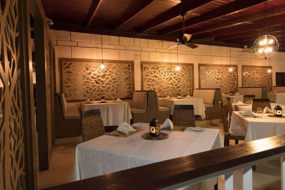 Restaurant interior with set tables and ornate wall designs under warm lighting at All Seasons Resort Europa