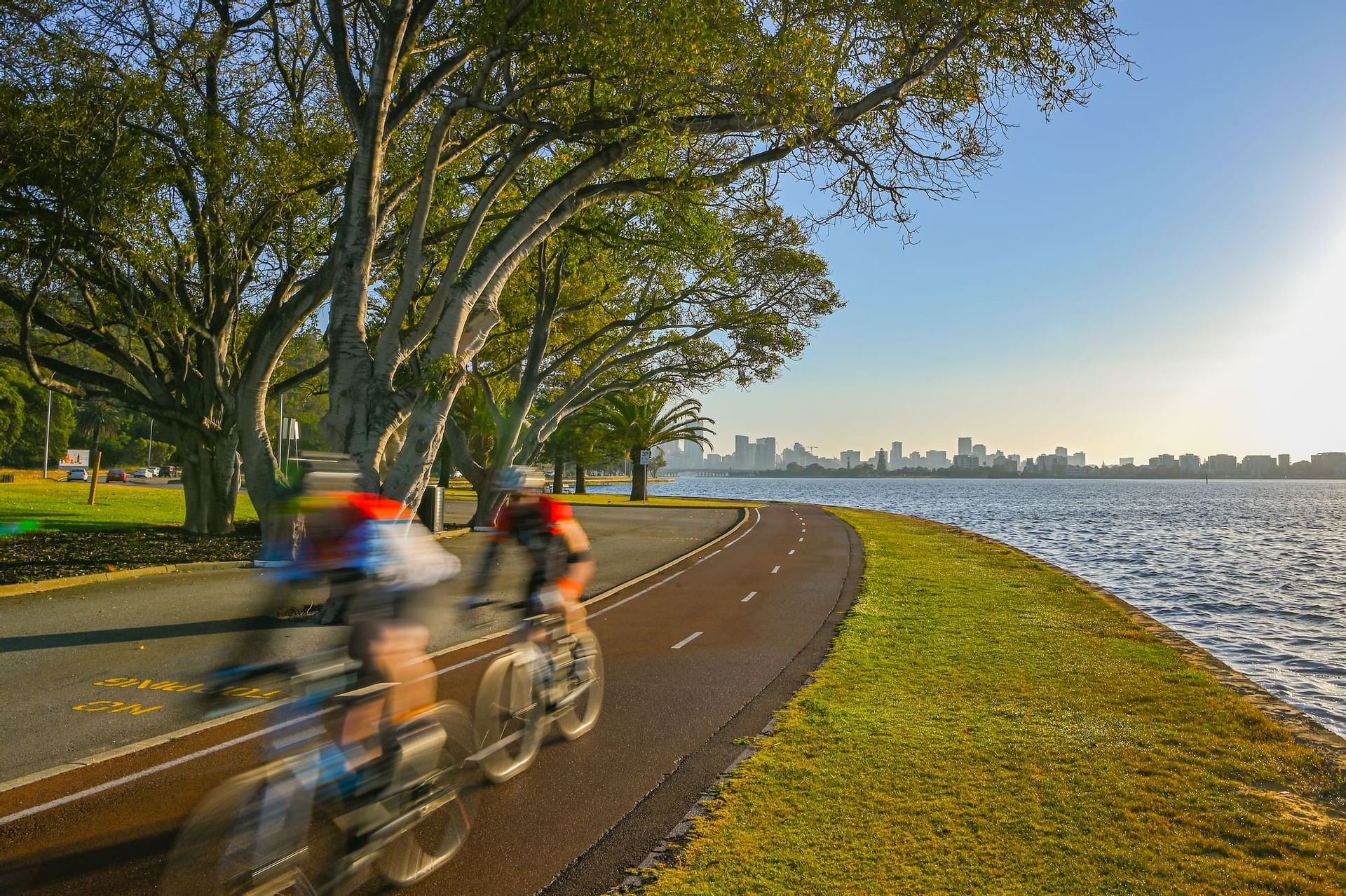 2 cyclists riding on a path by the lake near Nesuto Mounts Bay