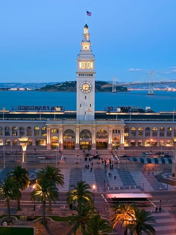 Ferry Building by palm trees under a twilight sky near the waterfront near Warwick San Francisco