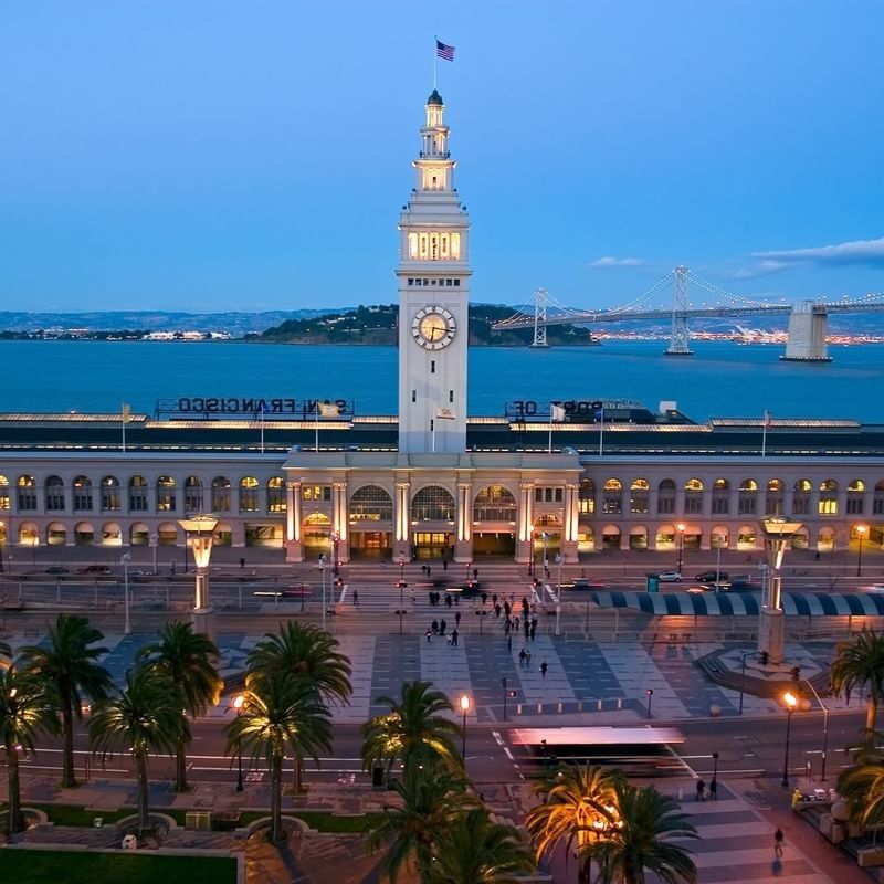 Ferry Building by palm trees under a twilight sky near the waterfront near Warwick San Francisco
