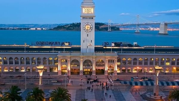Ferry Building by palm trees under a twilight sky near the waterfront near Warwick San Francisco