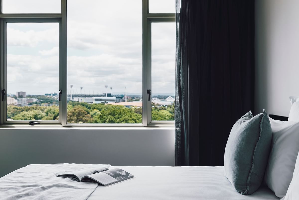 Magazine on the bed in 1 Bedroom Deluxe Apartment at Quay West Suites Melbourne