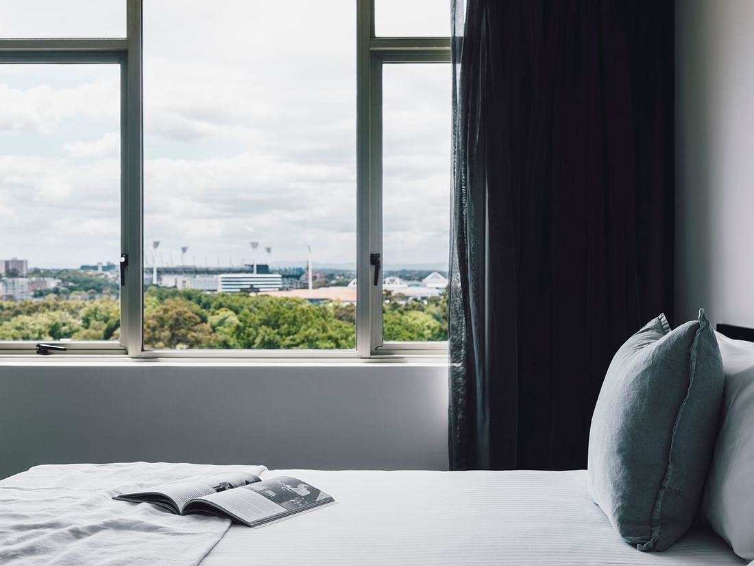 Magazine on the bed in 1 Bedroom Deluxe Apartment at Quay West Suites Melbourne