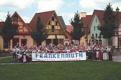 People holding Frankenmuth banner near Marv Herzog Hotel