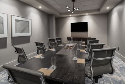 boardroom with long table, chairs and television
