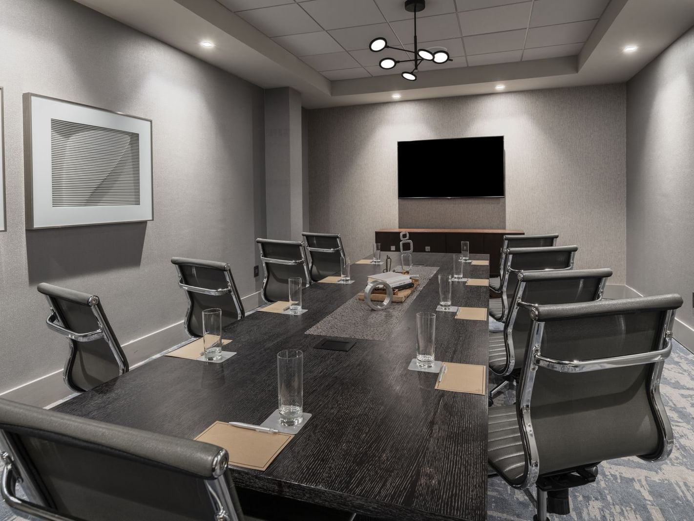 boardroom with table, chairs and television on wall