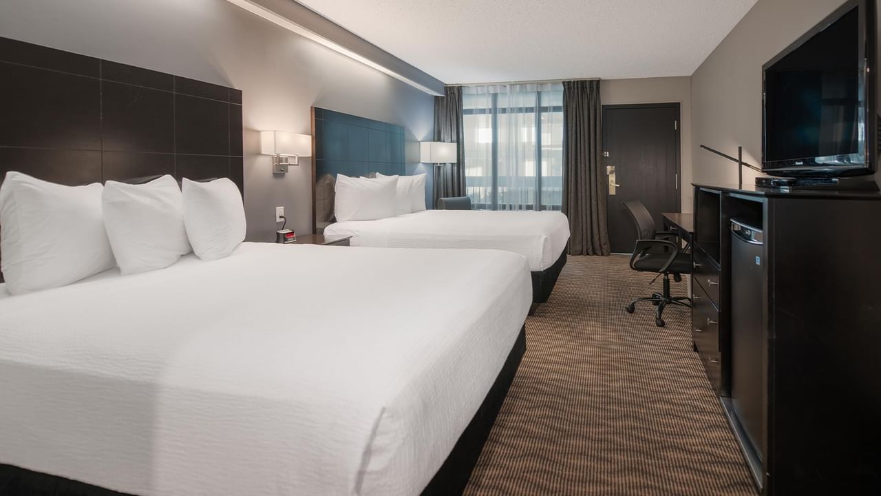 Two queen beds, TV, desk, and chair.