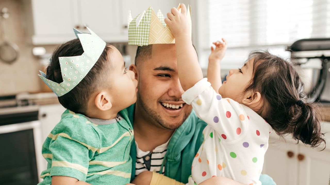 father with two kids and wearing paper made crowns