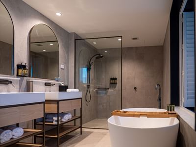Bravo Suite bathroom featuring vanity with double sinks, a glass shower, and a freestanding bathtub at Encore By Mingara