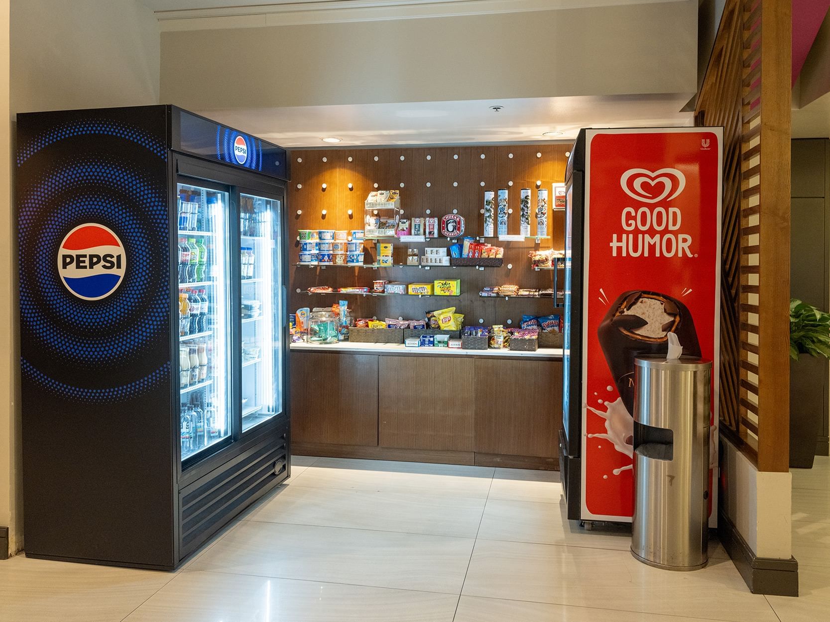 A hotel mini-market with a Pepsi refrigerator, a Good Humor ice cream machine, and snack shelves.