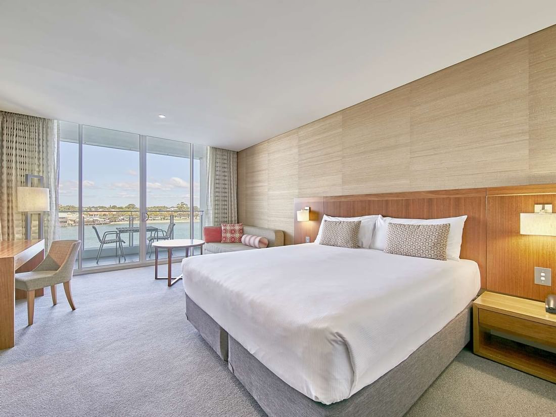 Bright Water View Superior King at The Sebel Mandurah with a king-size bed, desk, and balcony with outdoor seating